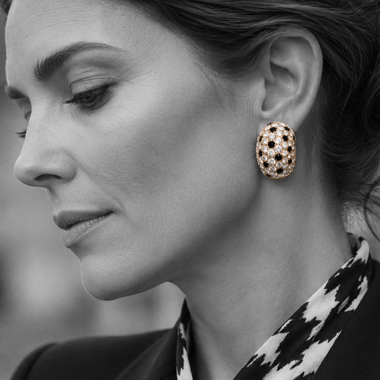 A pair of clip earrings, all over pavé set with brilliant cut diamonds and onyx. Signed Van Cleef & Arpels, Paris. Made ca 1980.