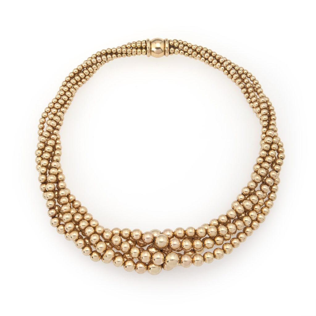 An eighteen carat yellow gold necklace composed of strands of plain round beads. Signed Cartier, made in Paris, manufactured circa 1950.