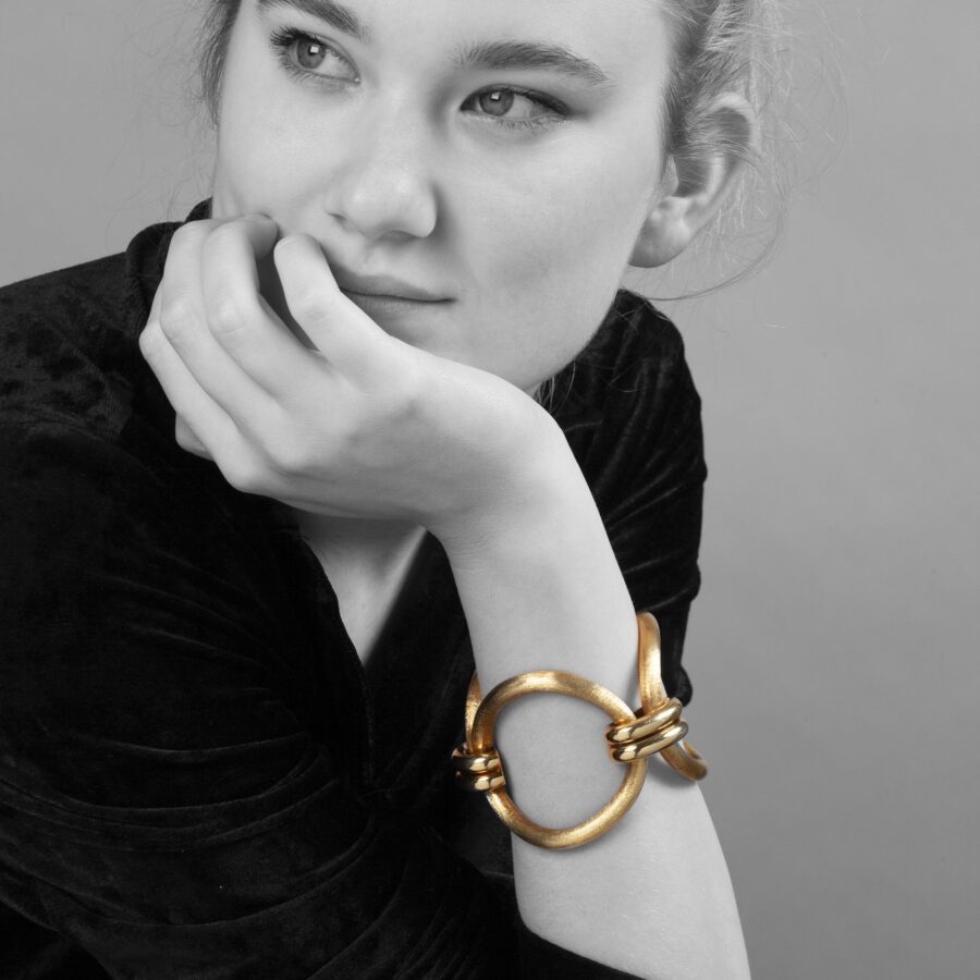 An eighteen carat yellow gold bracelet comprising three large circular curved links with satiné finish. Signed Cartier, made ca 1960 and numbered.