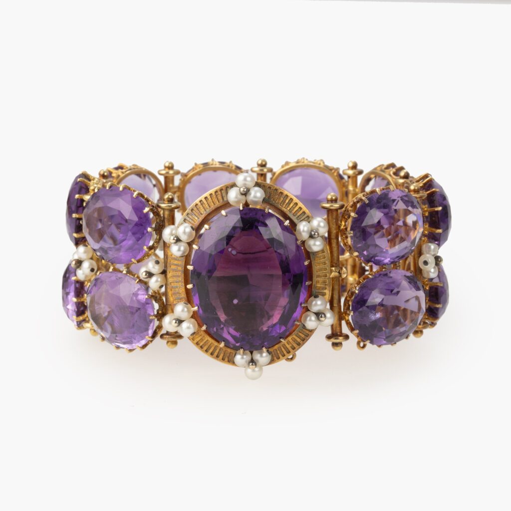 An antique eighteen carat pinkish gold bracelet set with oval facetted amethysts and clusters of pearls, on a large oval catch lock, made ca 1870.