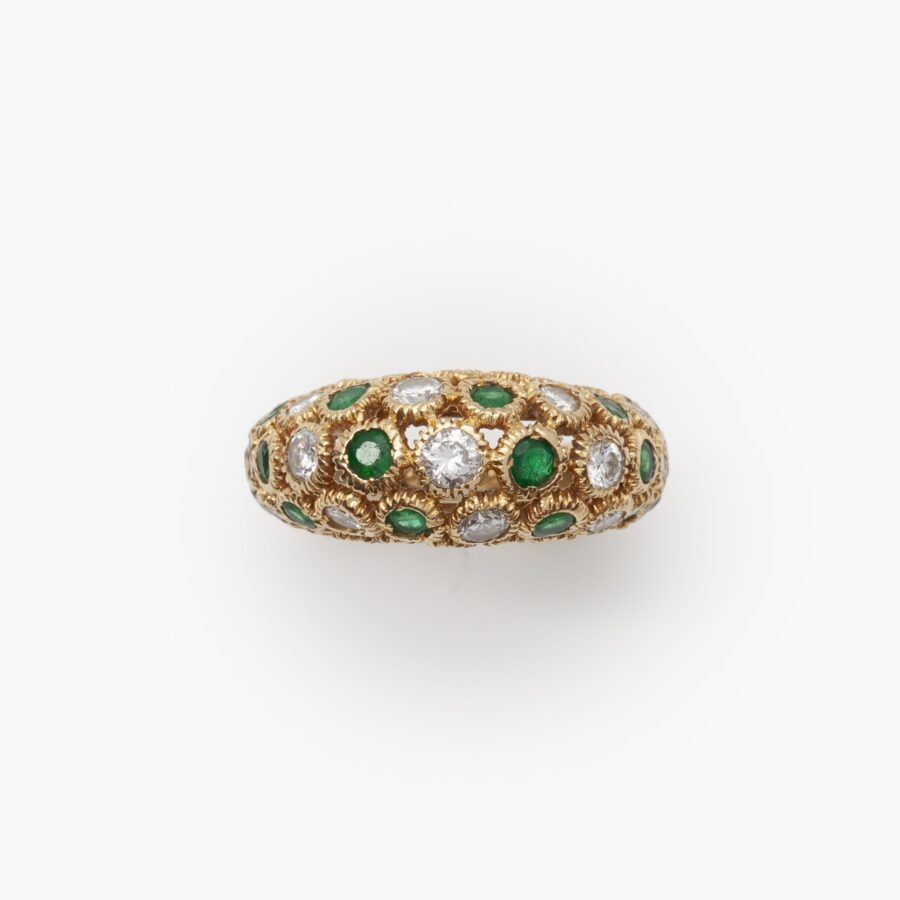 An eighteen carat yellow gold ring of bombé design, set with emeralds and diamonds. Signed Van Cleef & Arpels and numbered. Made in Paris and dated 1975.