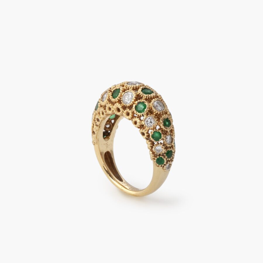 An eighteen carat yellow gold ring of bombé design, set with emeralds and diamonds. Signed Van Cleef & Arpels and numbered. Made in Paris and dated 1975.