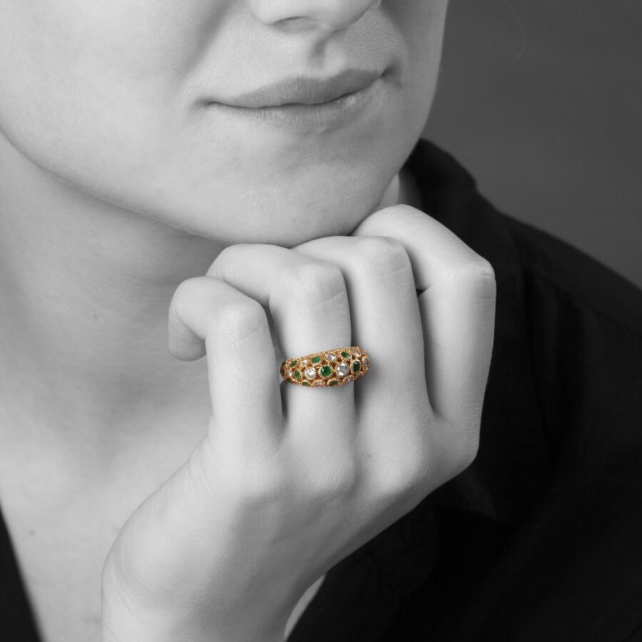 An eighteen carat yellow gold ring of bombé design, set with emeralds and diamonds. Signed Van Cleef & Arpels and numbered. Made in Paris and dated 1975.
