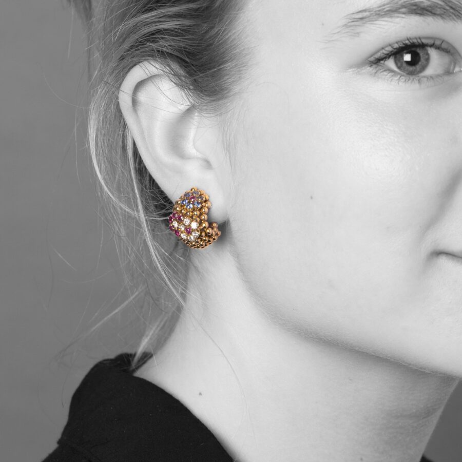 A pair of eighteen carat gold earclips model ‘Pelouse Hawaii’, set with diamonds, rubies and sapphires. Signed Van Cleef & Arpels, made ca 1950.