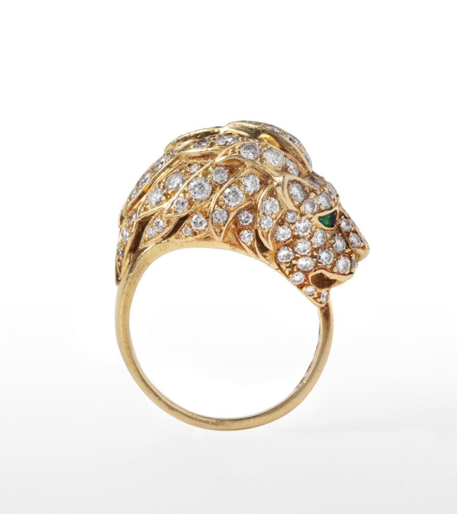 An eighteen carat yellow gold ring designed as a lion’s head, set with diamonds and with emerald eyes. Made by Georges Lenfant, in Paris, ca 1970.