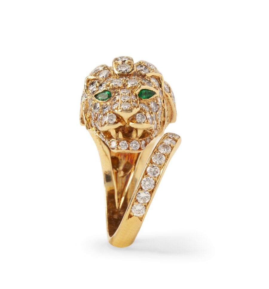 An eighteen carat yellow gold ring designed as a lion’s head, set with diamonds and with emerald eyes. Made by Georges Lenfant, in Paris, ca 1970.