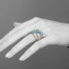 An eighteen carat yellow gold and platinum ring of triple bombé design, set with diamonds and turquoise. Signed Cartier Paris, made ca 1960.