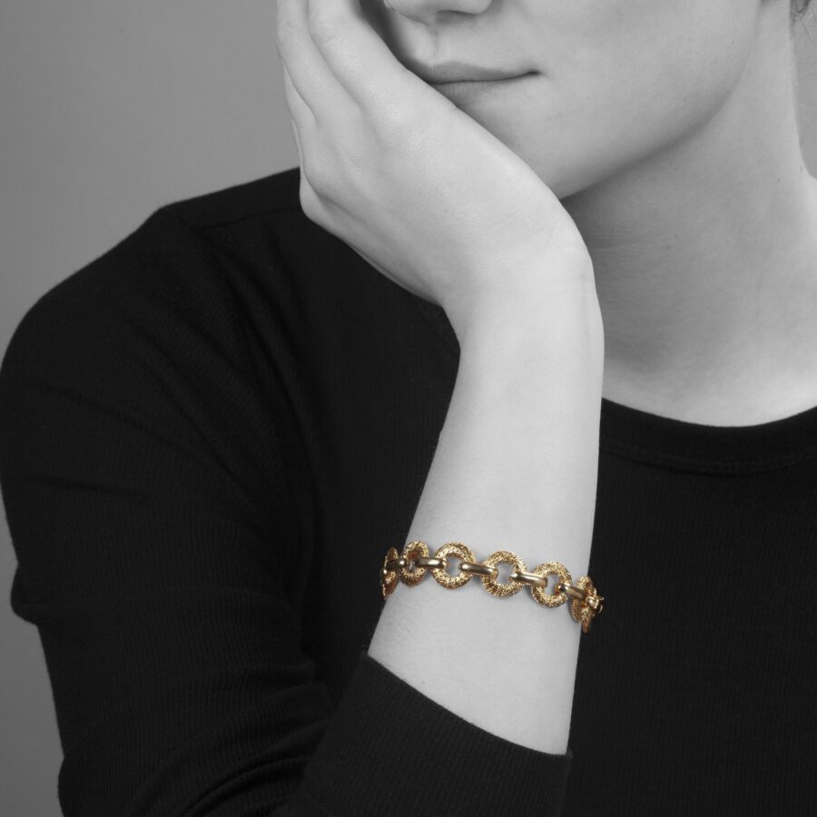 An eighteen carat yellow bracelet made of woven from goldwire flat circular links. Signed Fred, Paris, made by Georges Lenfant, Paris, ca 1970.