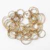 An eighteen carat yellow gold necklace with matching bracelet consisting of many strings of irregular round links. Signed Cartier, numbered. Made ca 1980.