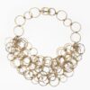 An eighteen carat yellow gold necklace with matching bracelet consisting of many strings of irregular round links. Signed Cartier, numbered. Made ca 1980.