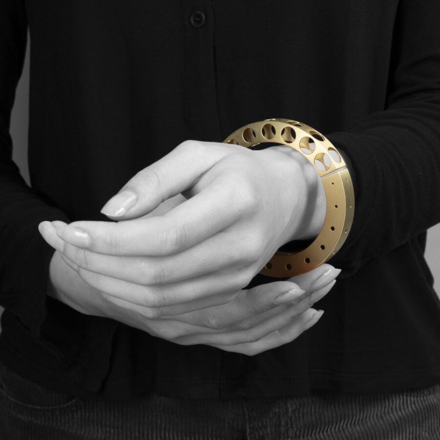 A fourteen carat yellow gold bangle 'Bracelet with Holes', signed Gijs Bakker, Amsterdam. Designed in 1992, part of the ‘Holes Project’.