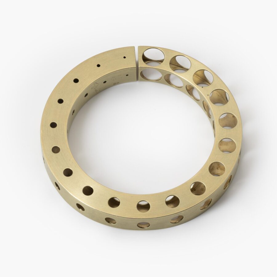 A fourteen carat yellow gold bangle 'Bracelet with Holes', signed Gijs Bakker, Amsterdam. Designed in 1992, part of the ‘Holes Project’.