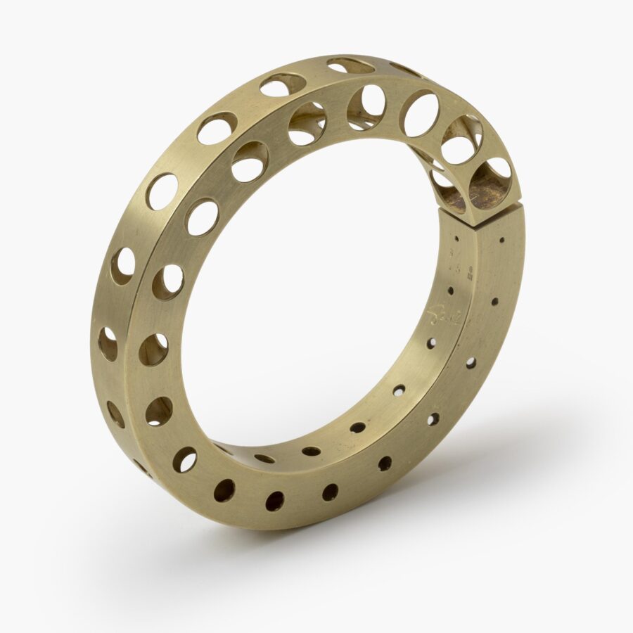 A fourteen carat yellow gold bangle 'Bracelet with Holes', signed Gijs Bakker, Amsterdam. Designed in 1992, part of the ‘Holes Project’.
