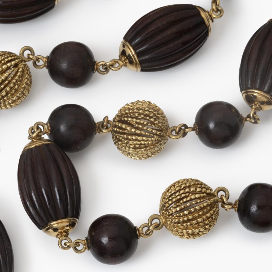 An eighteen carat yellow gold longchain made of beads carved from snakewood and of twisted gold wire. Signed Van Cleef & Arpels, Paris, made ca 1970.  