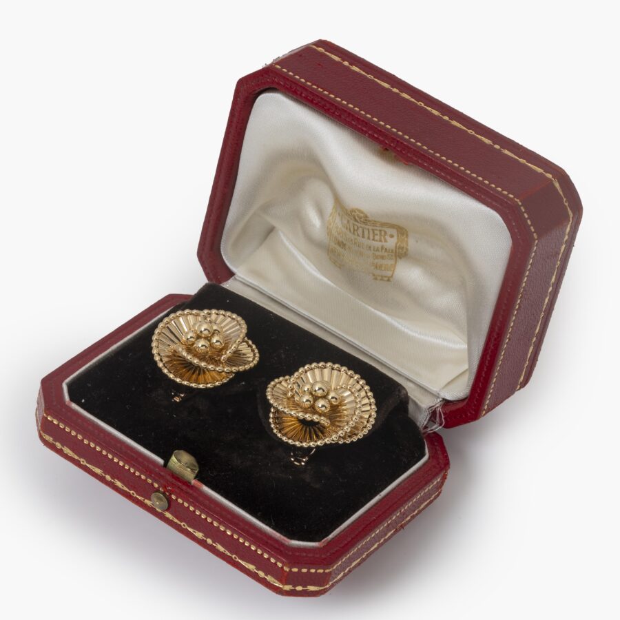 A pair of eighteen carat yellow gold tourbillon earrings designed as three intertwined ribbed ribbonss. Signed Cartier Paris, ca 1950. In original case.