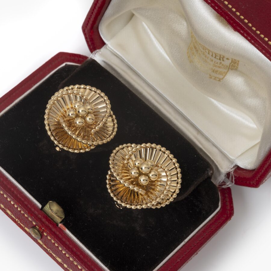 A pair of eighteen carat yellow gold tourbillon earrings designed as three intertwined ribbed ribbonss. Signed Cartier Paris, ca 1950. In original case.