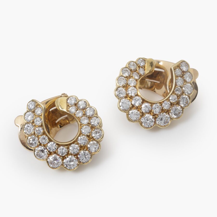 A pair of eighteen carat yellow gold clip earrings pavé set with brilliant cut diamonds. Signed Van Cleef & Arpels and numbered, made in Paris, around 1980. 