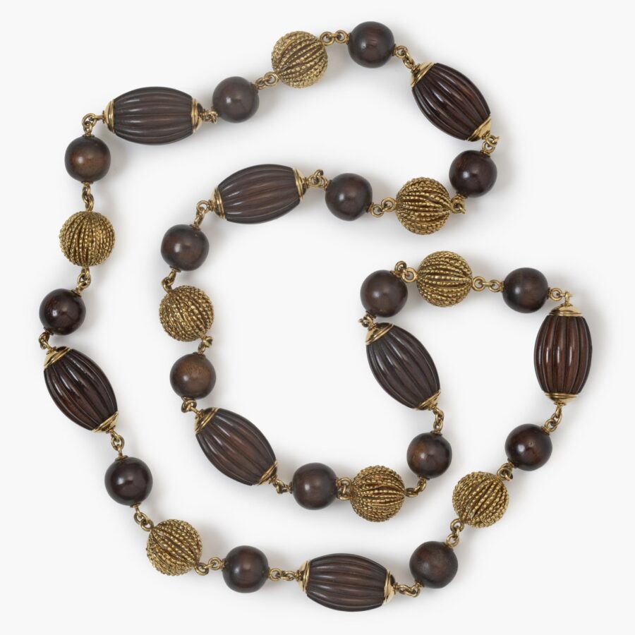 An eighteen carat yellow gold longchain made of beads carved from snakewood and of twisted gold wire. Signed Van Cleef & Arpels, Paris, made ca 1970.  
