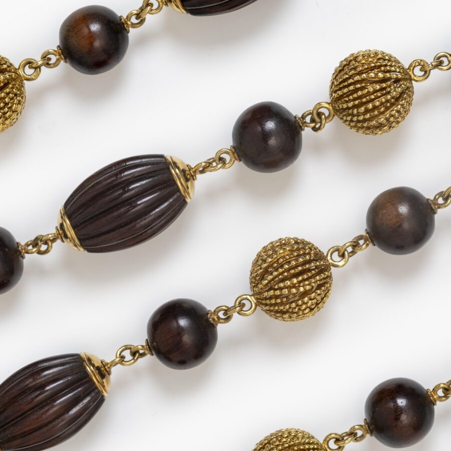 An eighteen carat yellow gold longchain made of beads carved from snakewood and of twisted gold wire. Signed Van Cleef & Arpels, Paris, made ca 1970.  