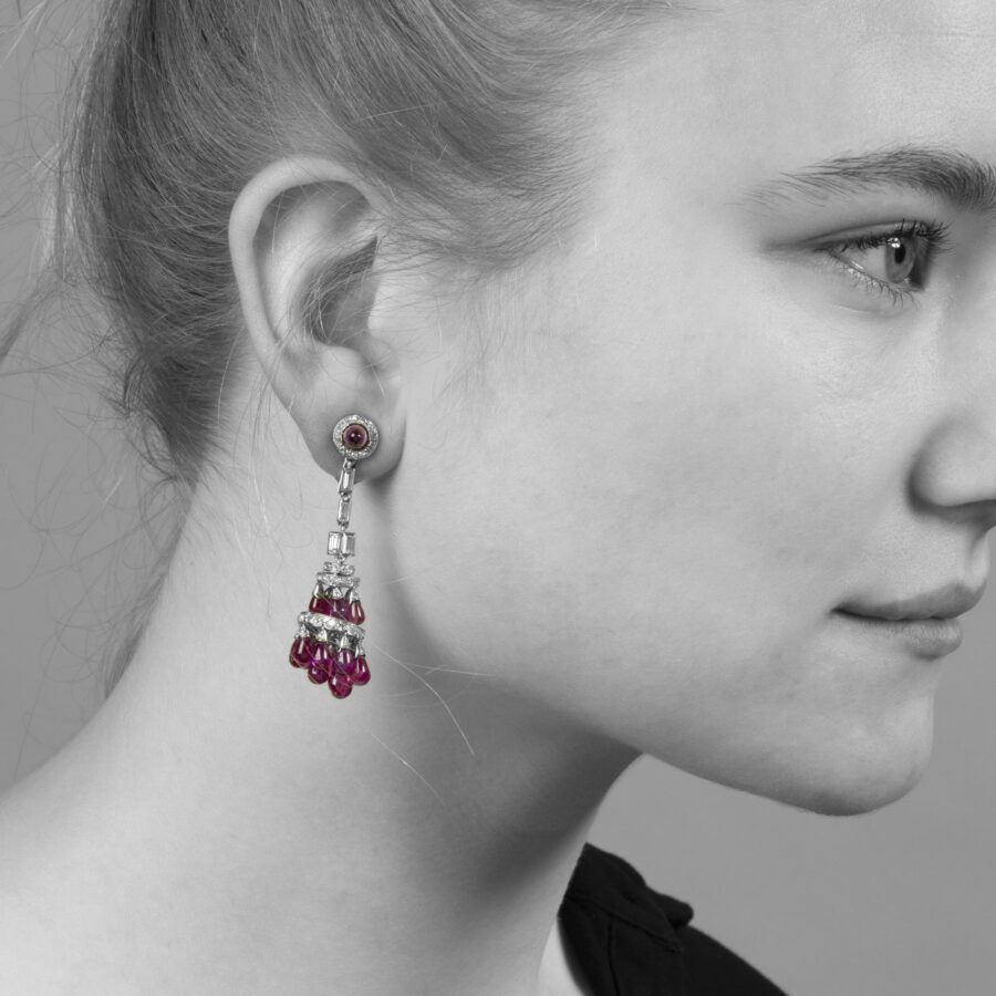 A pair of platinum Art Deco earrings, each mounted with plain drops of rubies and set with diamonds in various cuts, made ca 1920.