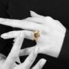 A fourteen carat yellow gold kinetic ring designed as two rotating open squares, each with one diamond. Signed N. Teufel, USA, dated 1972.