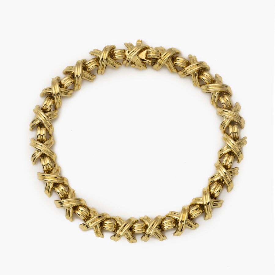 An eightteen carat yellow gold bracelet “Signature X” comprising nineteen x-shaped links, interconnected by bridge-shaped links, with box clasp with safety guard. After a design by Jean Schlumberger. Signed Tiffany & Co., USA.
