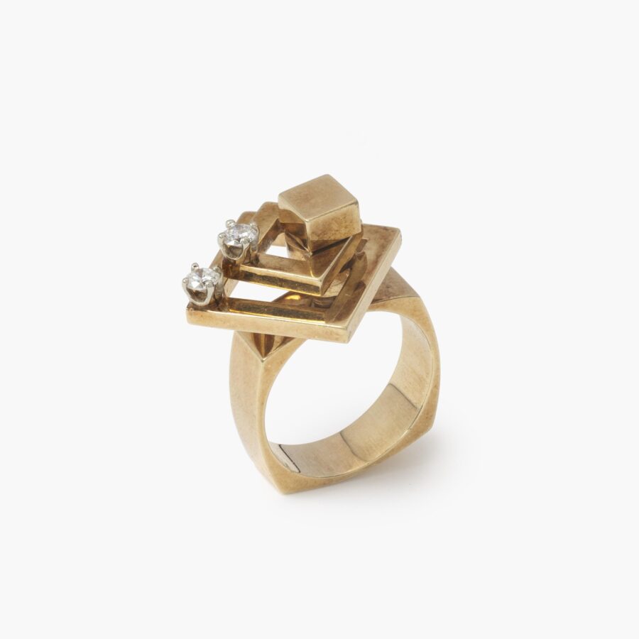 A fourteen carat yellow gold kinetic ring designed as two rotating open squares, each with one diamond. Signed N. Teufel, USA, dated 1972.