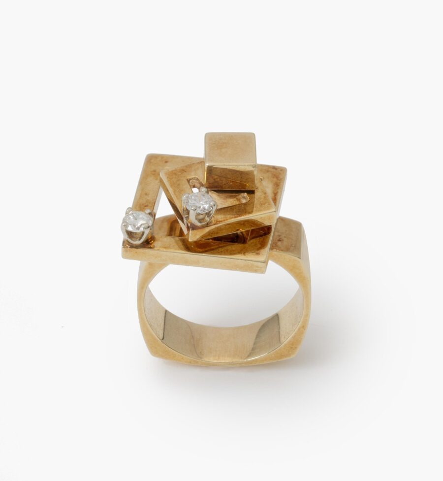A fourteen carat yellow gold kinetic ring designed as two rotating open squares, each with one diamond. Signed N. Teufel, USA, dated 1972.