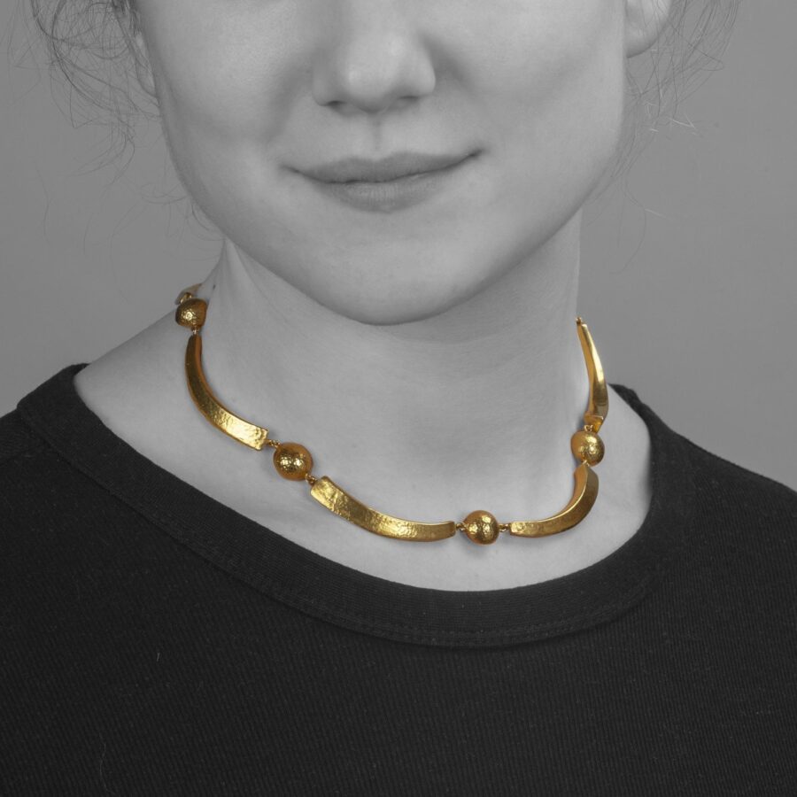 An eighteen carat yellow gold necklace with hammered texture, comprising cresents an half domes. Signed Ilias Lalaounis, made in Athens, Greec