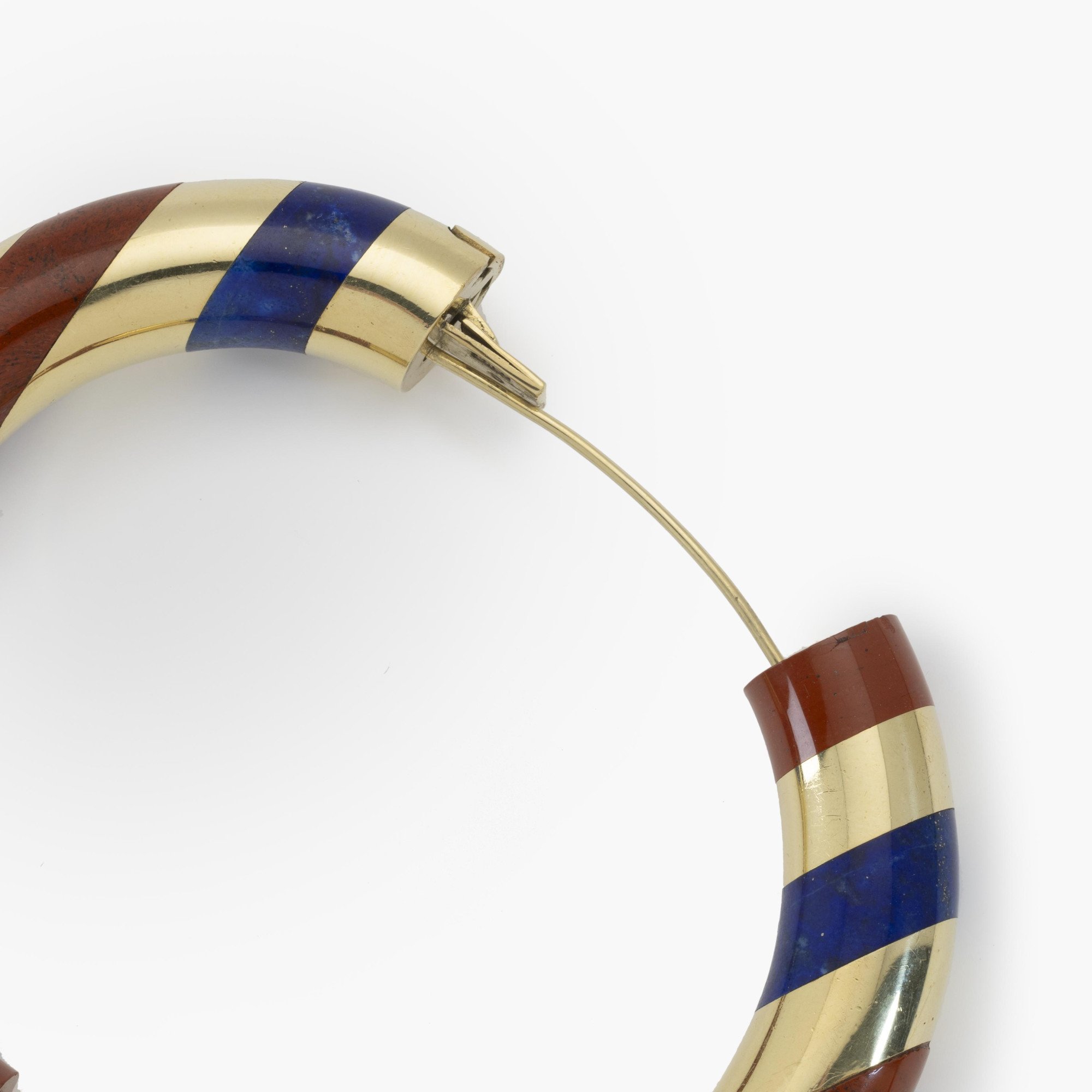 An eighteen-karat yellow gold rigid bracelet with bands of red jasper and lapis lazuli. Signed Tiffany & Co., made circa 1977. Designed by Angela Cummings.