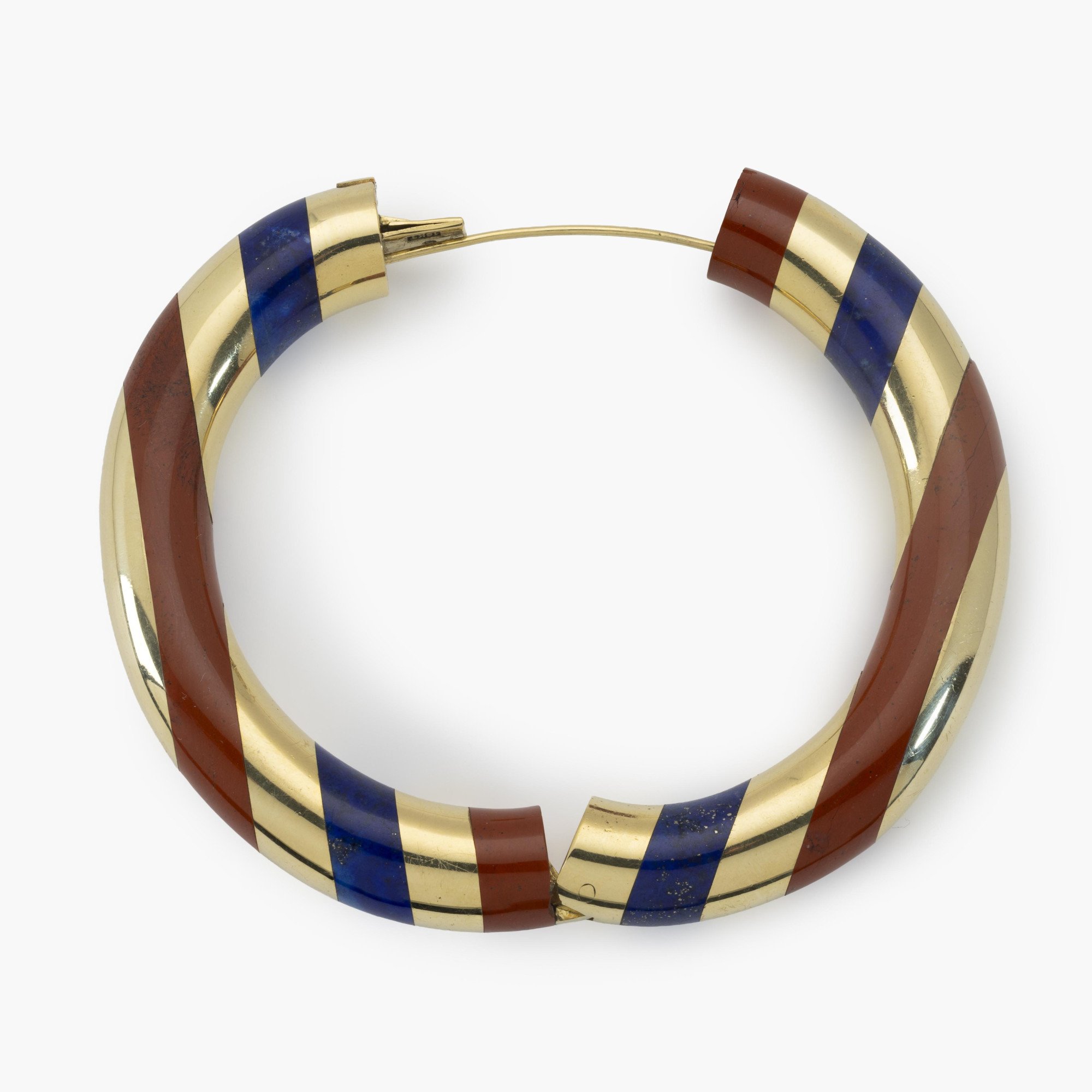 An eighteen-karat yellow gold rigid bracelet with bands of red jasper and lapis lazuli. Signed Tiffany & Co., made circa 1977. Designed by Angela Cummings.