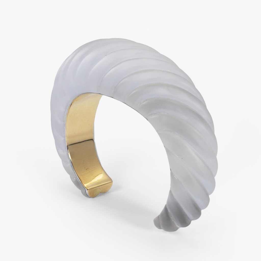 An eighteen carat yellow gold bangle, on which a large satinated rock crystal cut as twisted rope. Signed Cartier Paris, made ca 1975 and numbered.