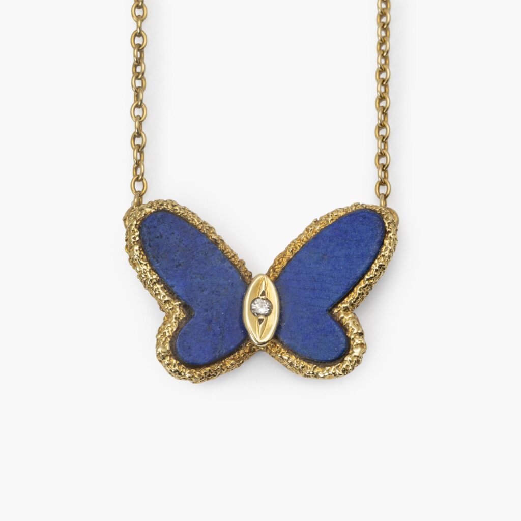 An eighteen carat yellow gold pendant designed as a butterfly carved from lapis lazuli. Signed Van Cleef & Arpels, Paris, ca 1970. With original pouch.