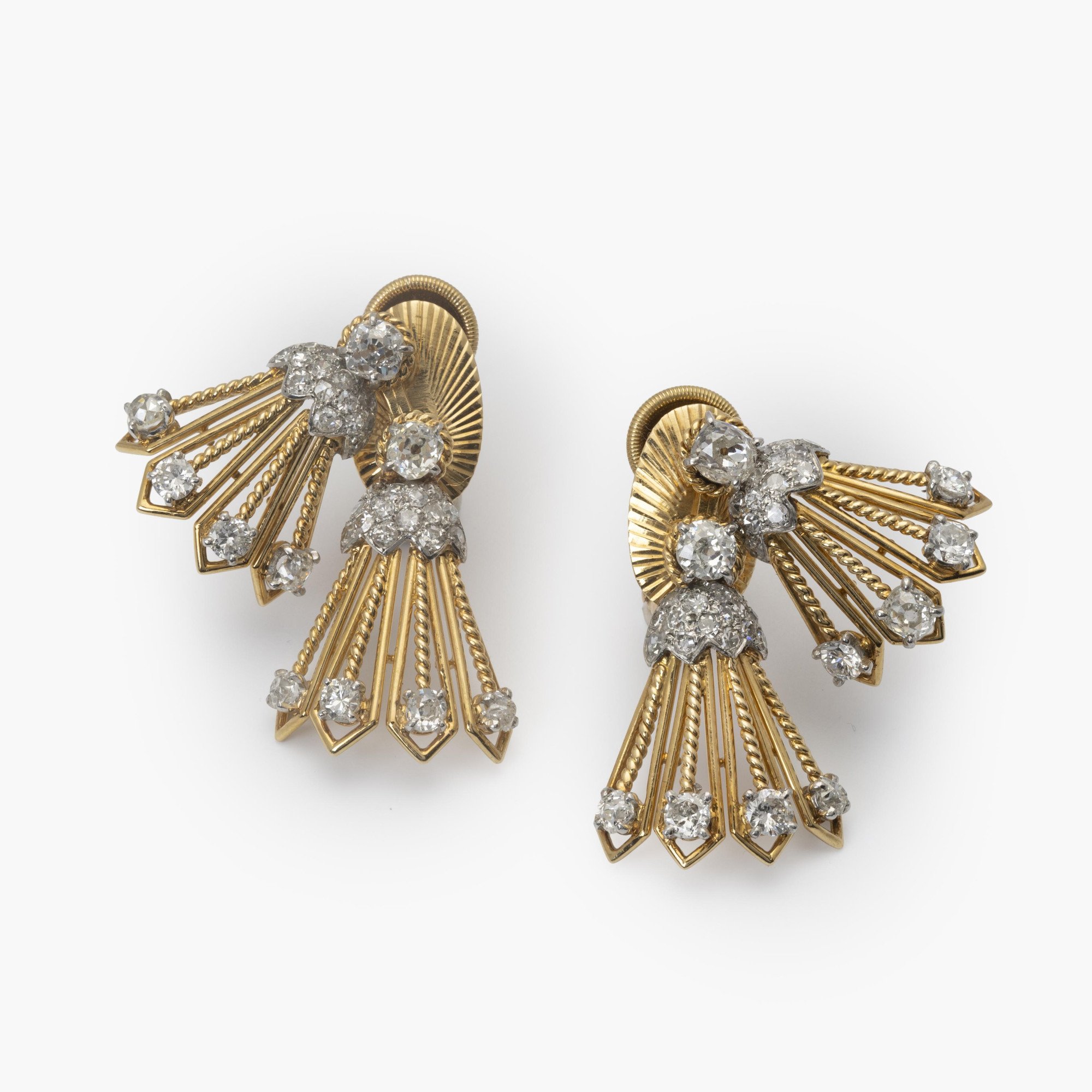 A pair of eighteen carat yellow gold and platinum earrings, each with rotating tassels. Signed Monture Cartier, Paris, circa 1950.
