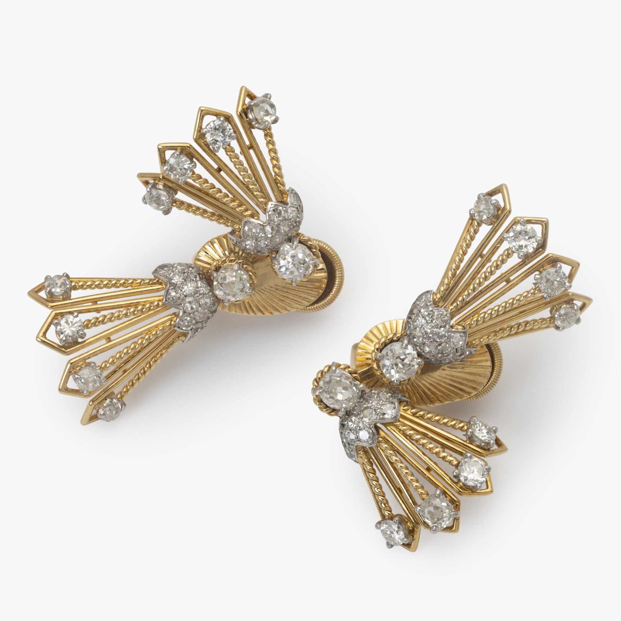 A pair of eighteen carat yellow gold and platinum earrings, each with rotating tassels. Signed Monture Cartier, Paris, circa 1950.