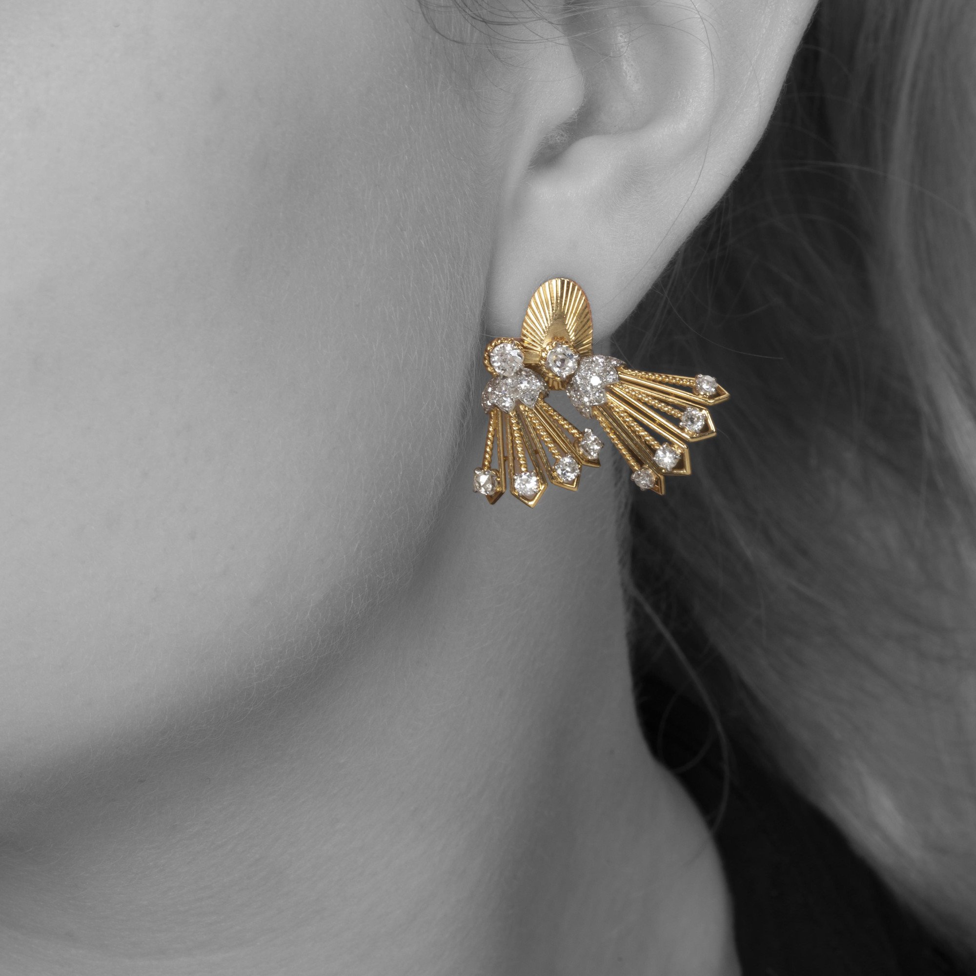 A pair of eighteen carat yellow gold and platinum earrings, each with rotating tassels. Signed Monture Cartier, Paris, circa 1950.