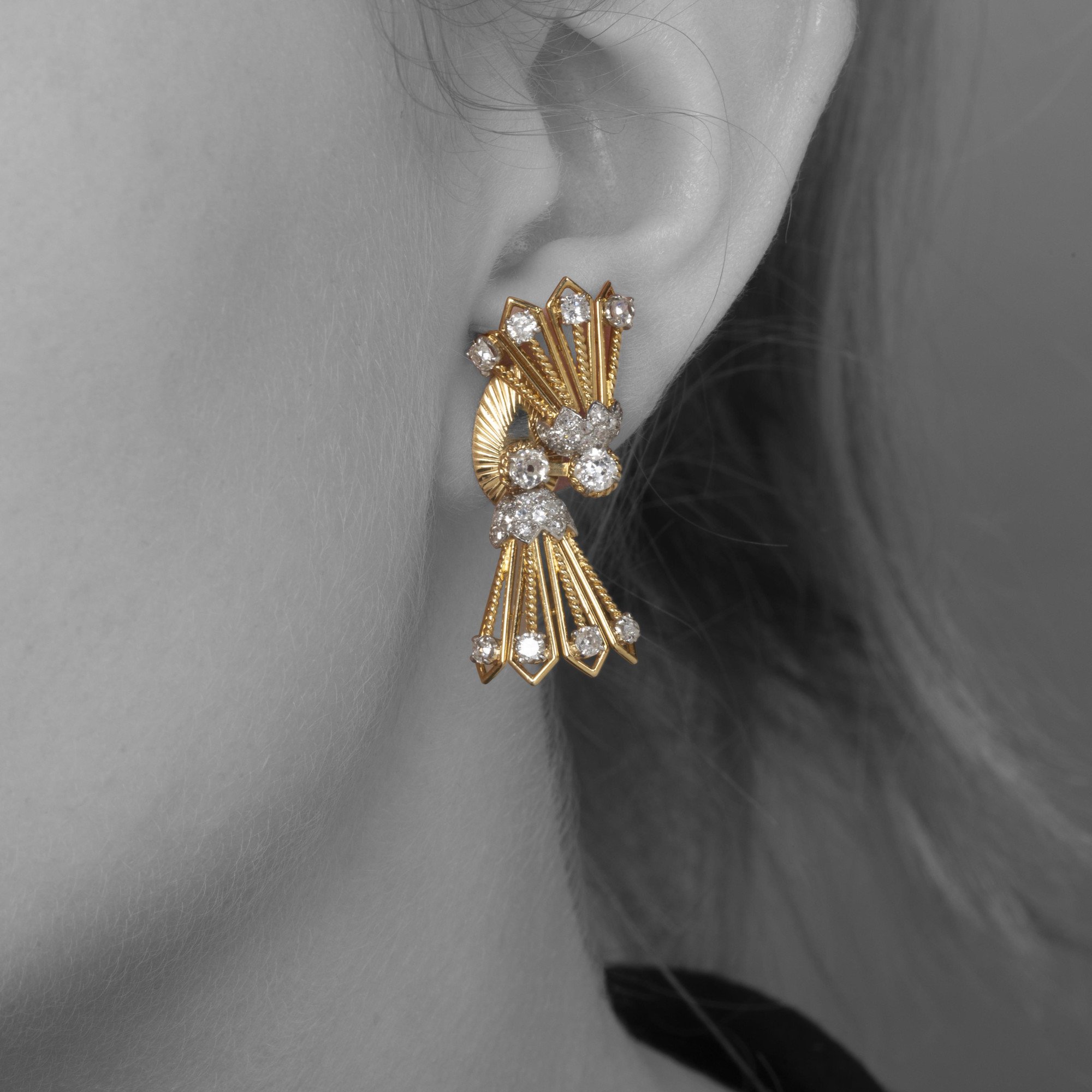 A pair of eighteen carat yellow gold and platinum earrings, each with rotating tassels. Signed Monture Cartier, Paris, circa 1950.