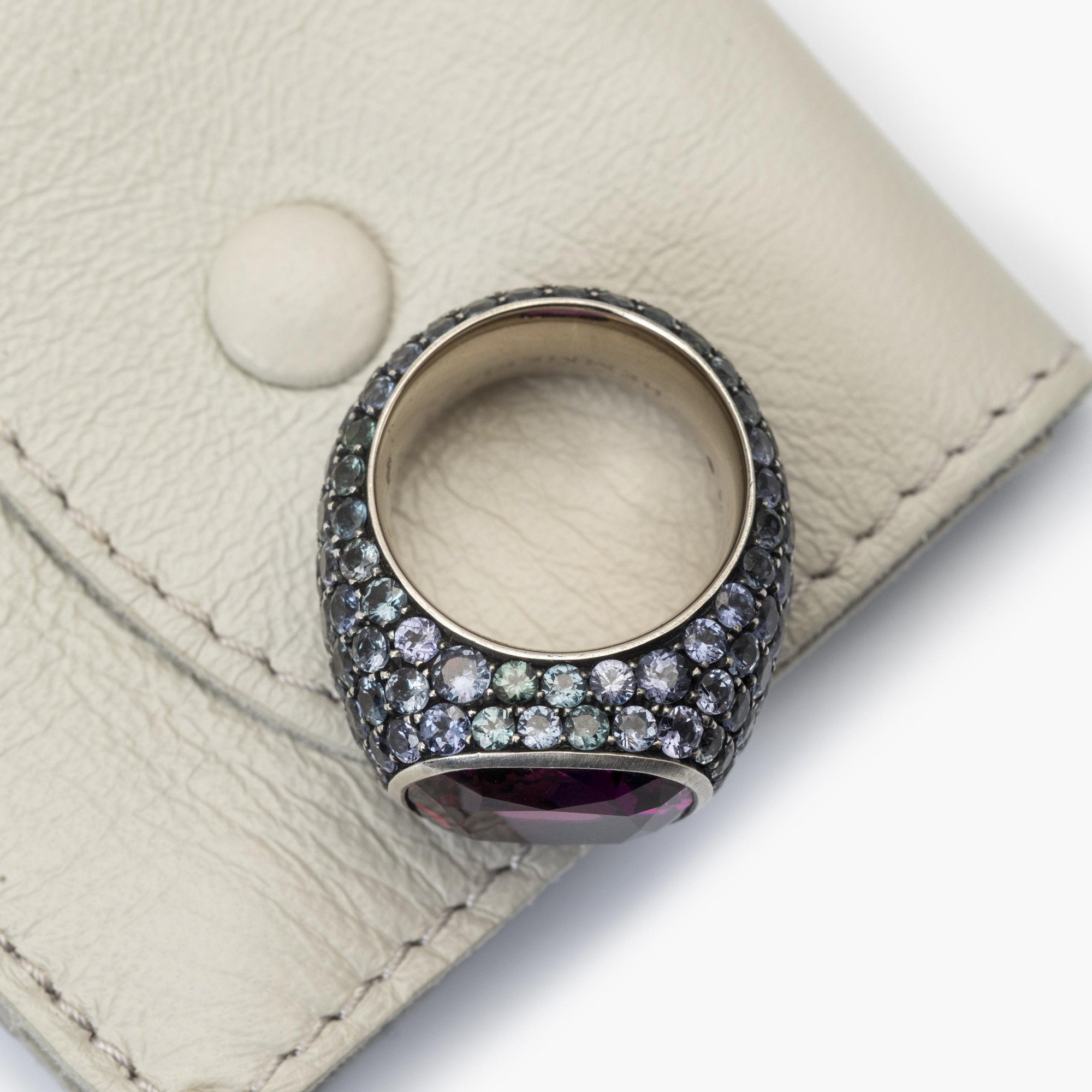 An eighteen-carat white gold and silver ring set with a very rare purple garnet and smaller purple-blue colour-change garnets. Hemmerle, Munich.