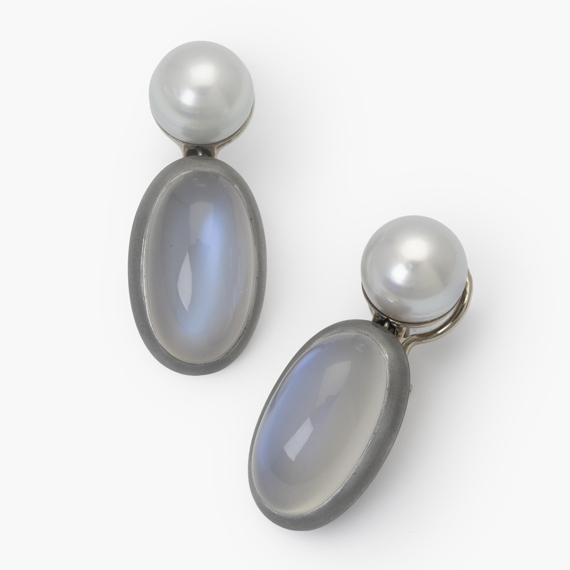 A pair of eighteen-carat white gold earrings, set with a South Sea pearl and a moonstone in aluminium. Signed Hemmerle, made in Munich. With original pouch.
