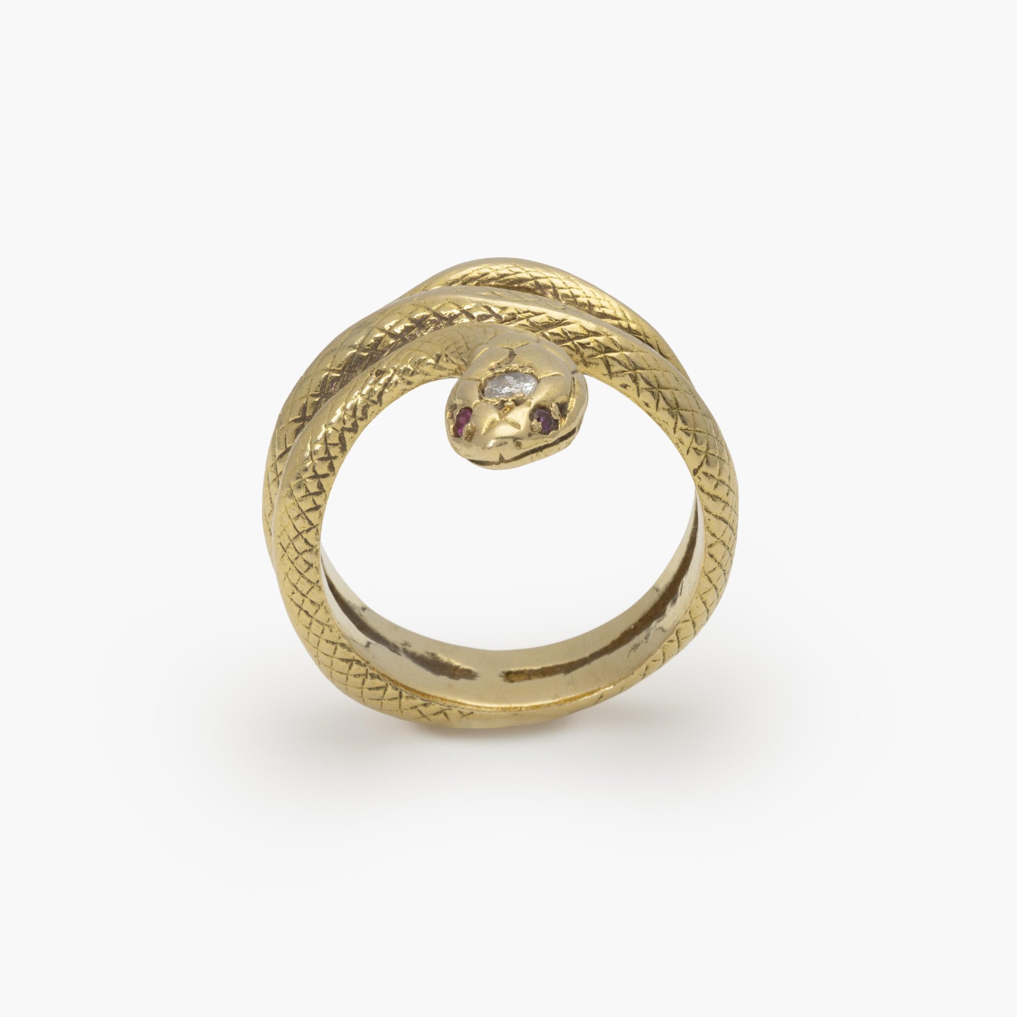 An eighteen-carat yellow gold ring designed as a snake; the head set with one brilliant-cut diamond and two rubies as eyes. Made ca 1960.