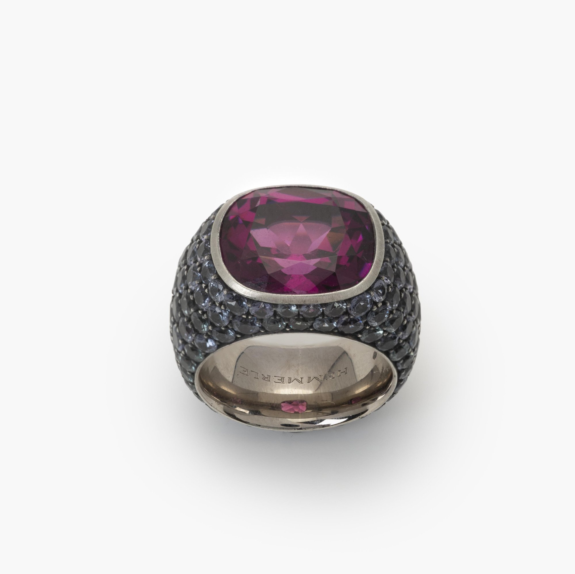 An eighteen-carat white gold and silver ring set with a very rare purple garnet and smaller purple-blue colour-change garnets. Hemmerle, Munich.