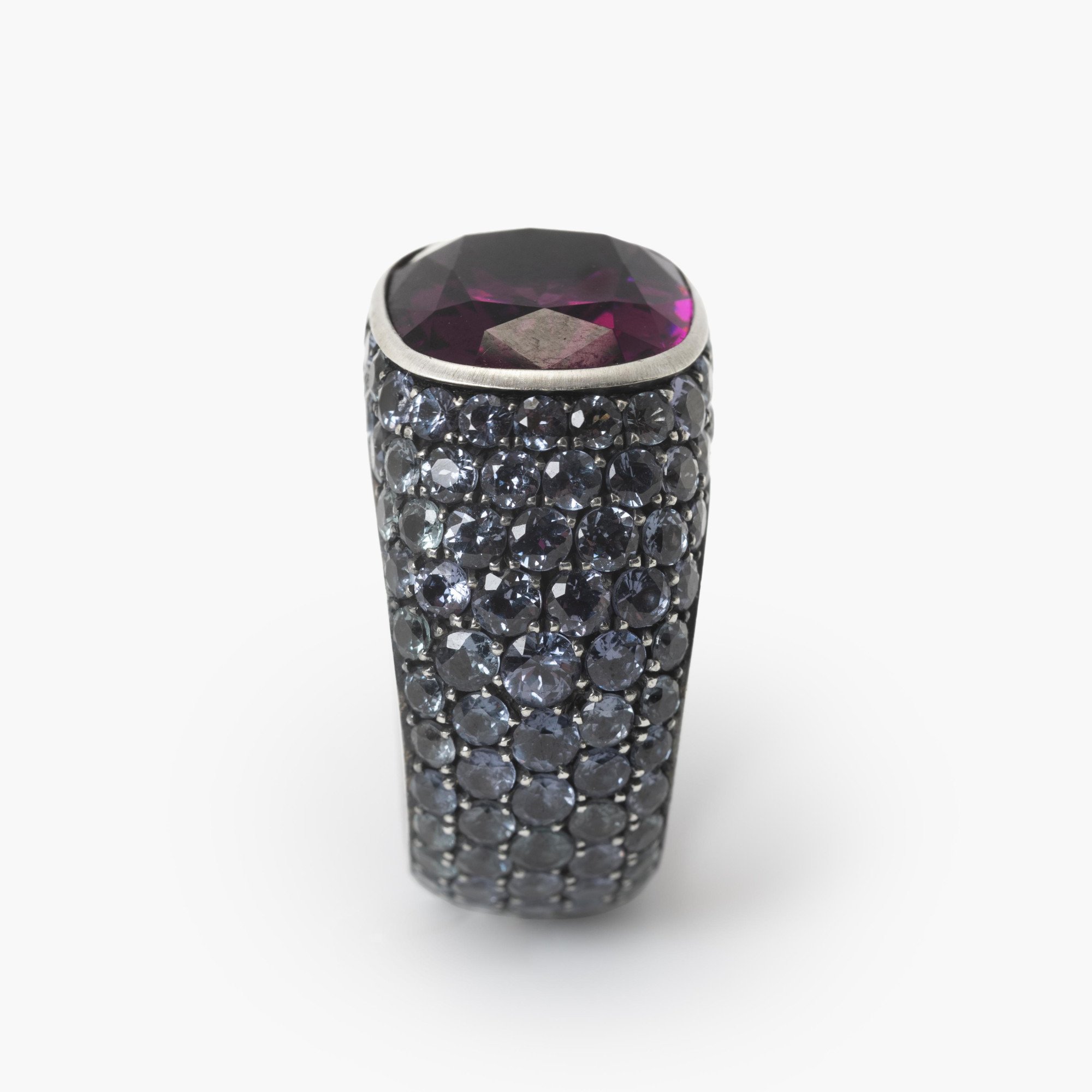 An eighteen-carat white gold and silver ring set with a very rare purple garnet and smaller purple-blue colour-change garnets. Hemmerle, Munich.