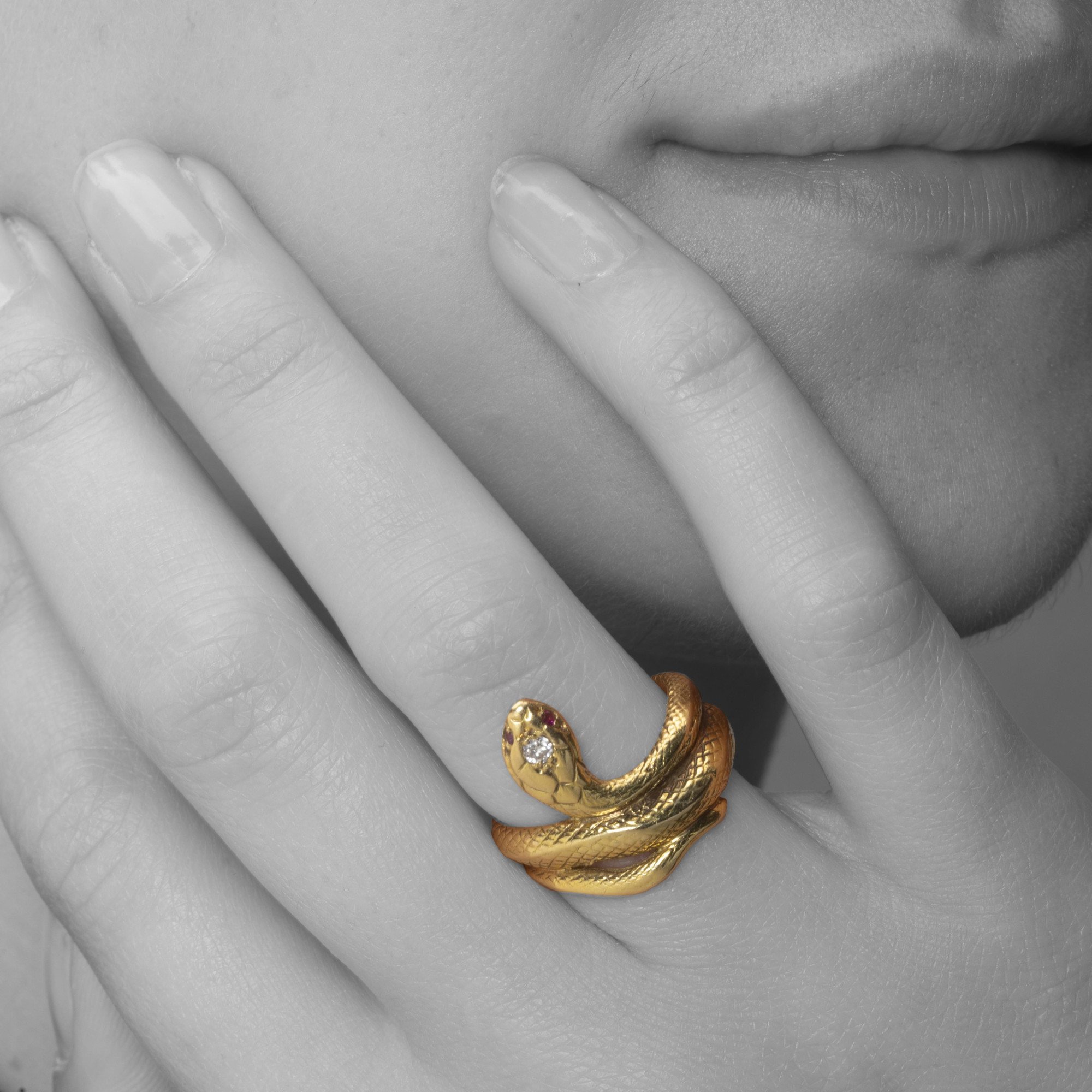 An eighteen-carat yellow gold ring designed as a snake; the head set with one brilliant-cut diamond and two rubies as eyes. Made ca 1960.