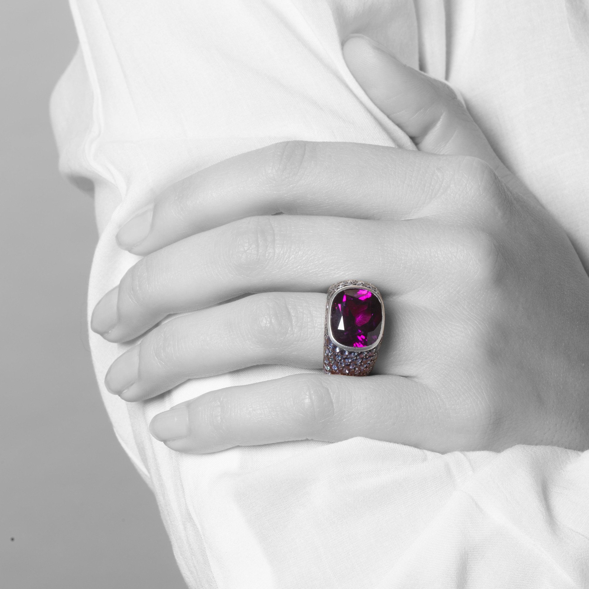 An eighteen-carat white gold and silver ring set with a very rare purple garnet and smaller purple-blue colour-change garnets. Hemmerle, Munich.