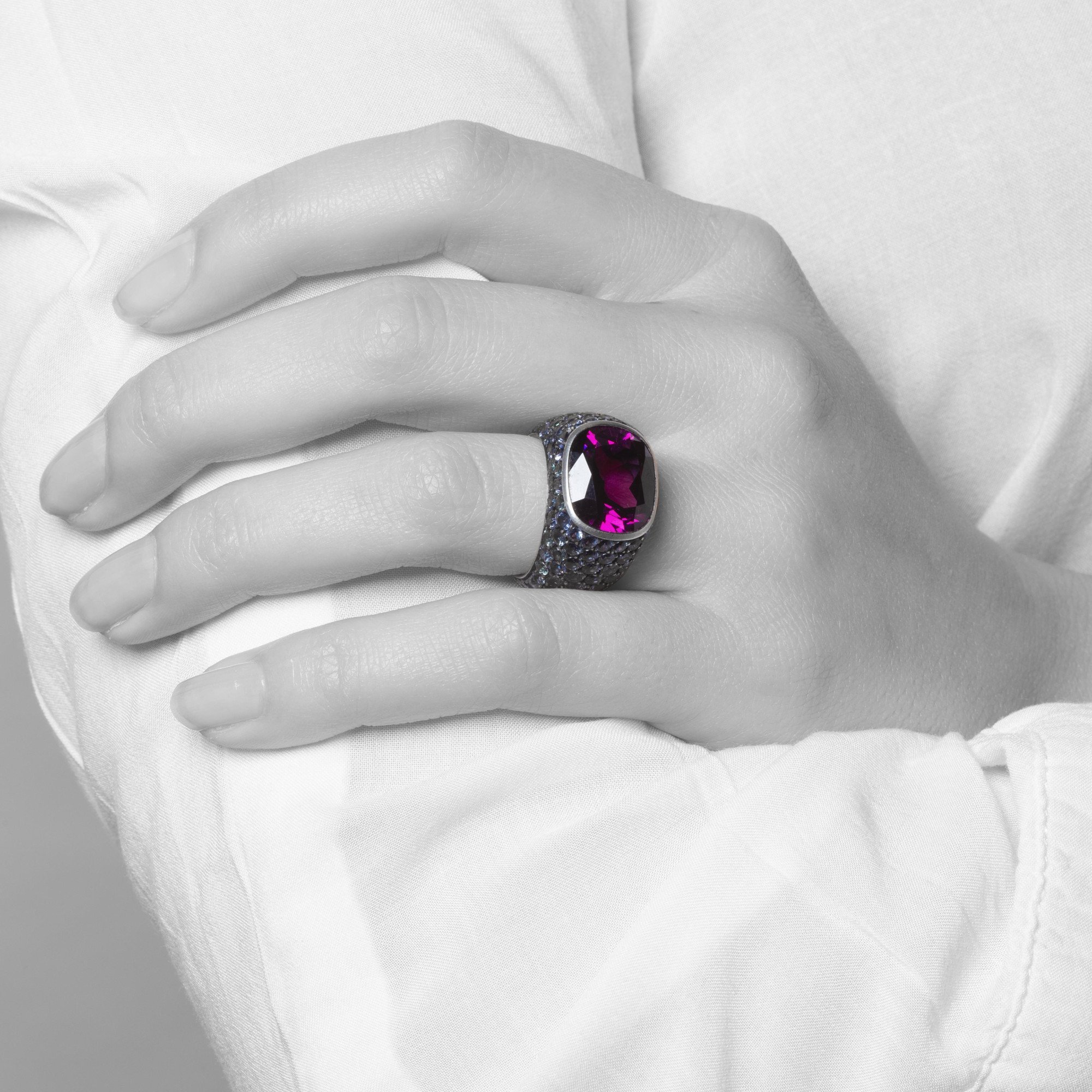 An eighteen-carat white gold and silver ring set with a very rare purple garnet and smaller purple-blue colour-change garnets. Hemmerle, Munich.