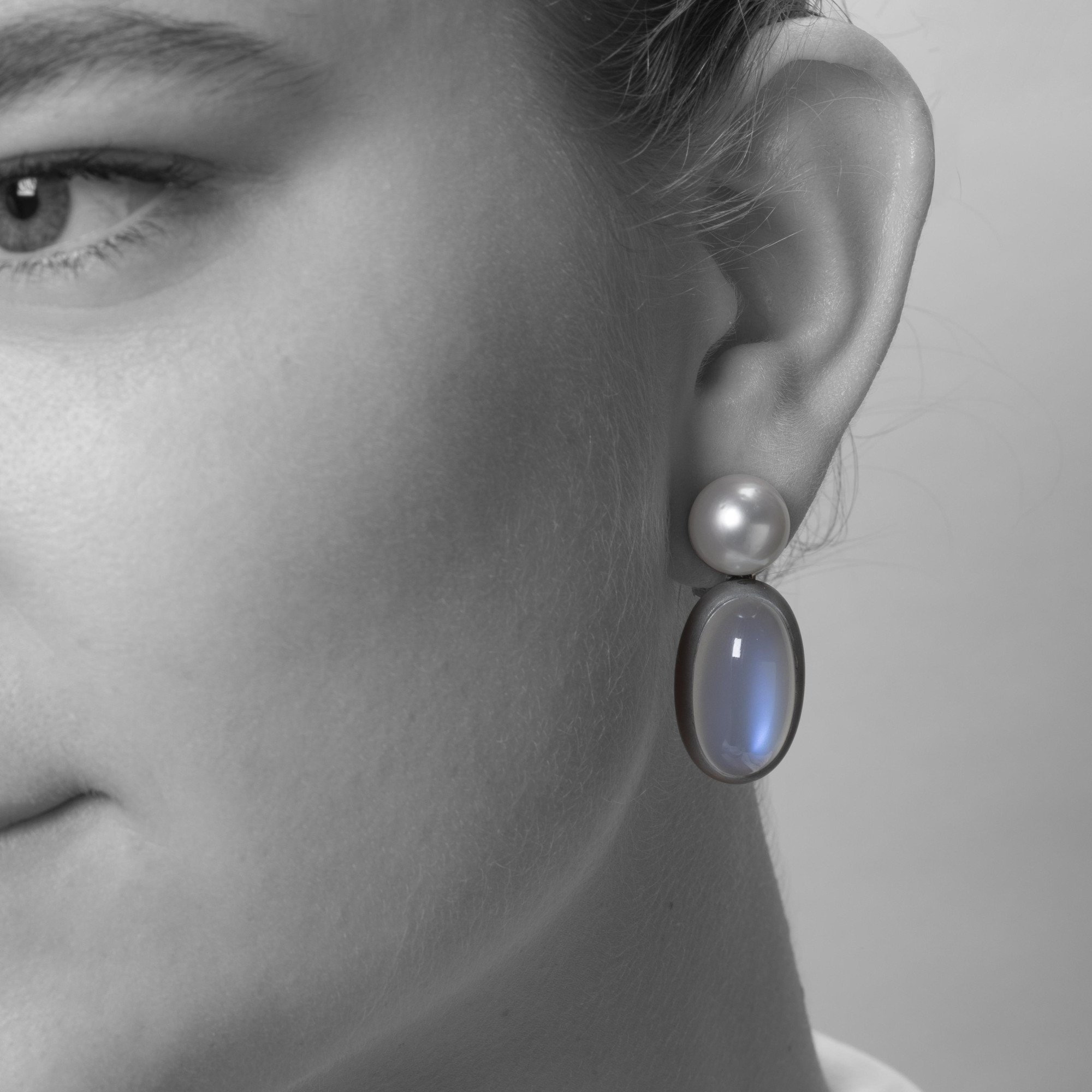 A pair of eighteen-carat white gold earrings, set with a South Sea pearl and a moonstone in aluminium. Signed Hemmerle, made in Munich. With original pouch.