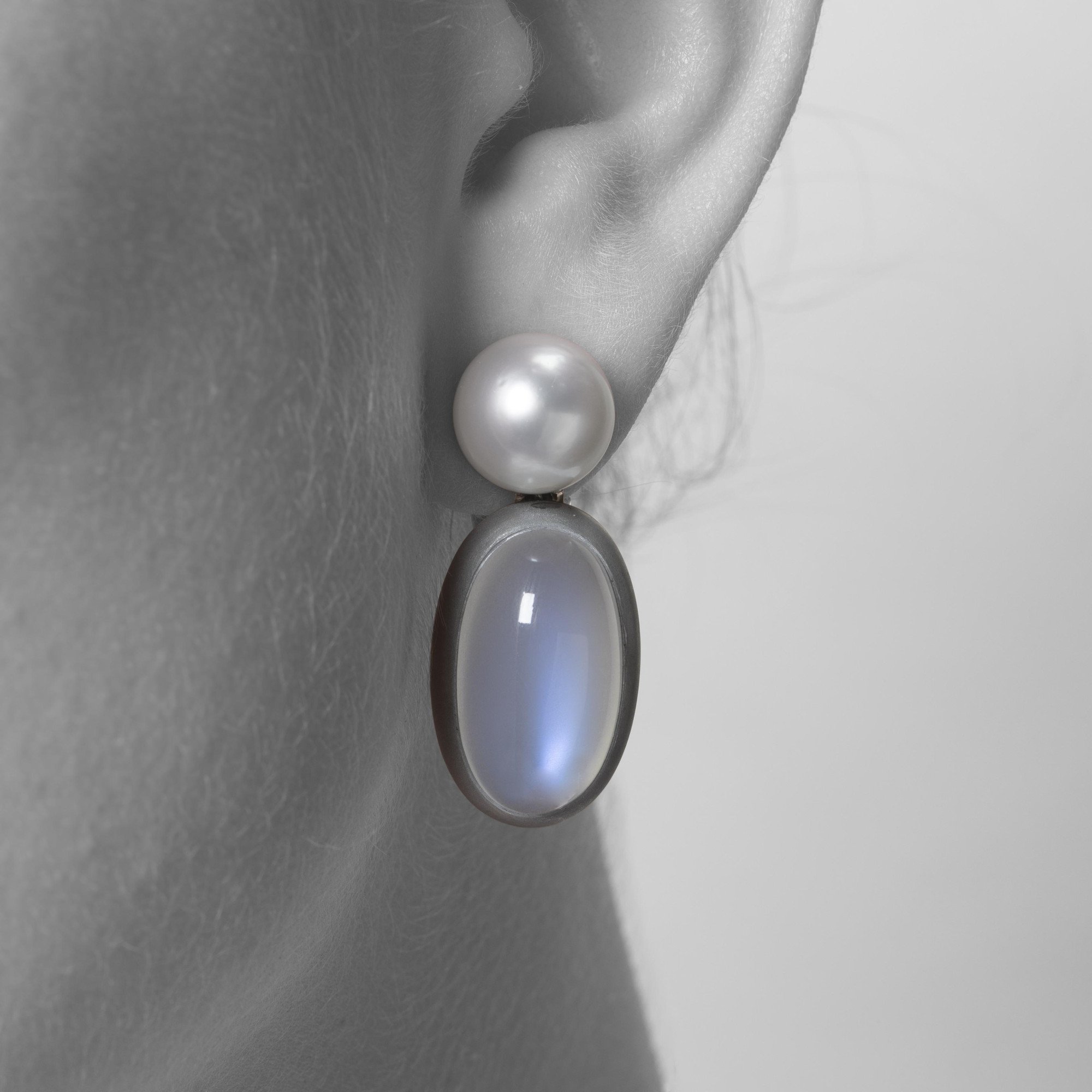 A pair of eighteen-carat white gold earrings, set with a South Sea pearl and a moonstone in aluminium. Signed Hemmerle, made in Munich. With original pouch.