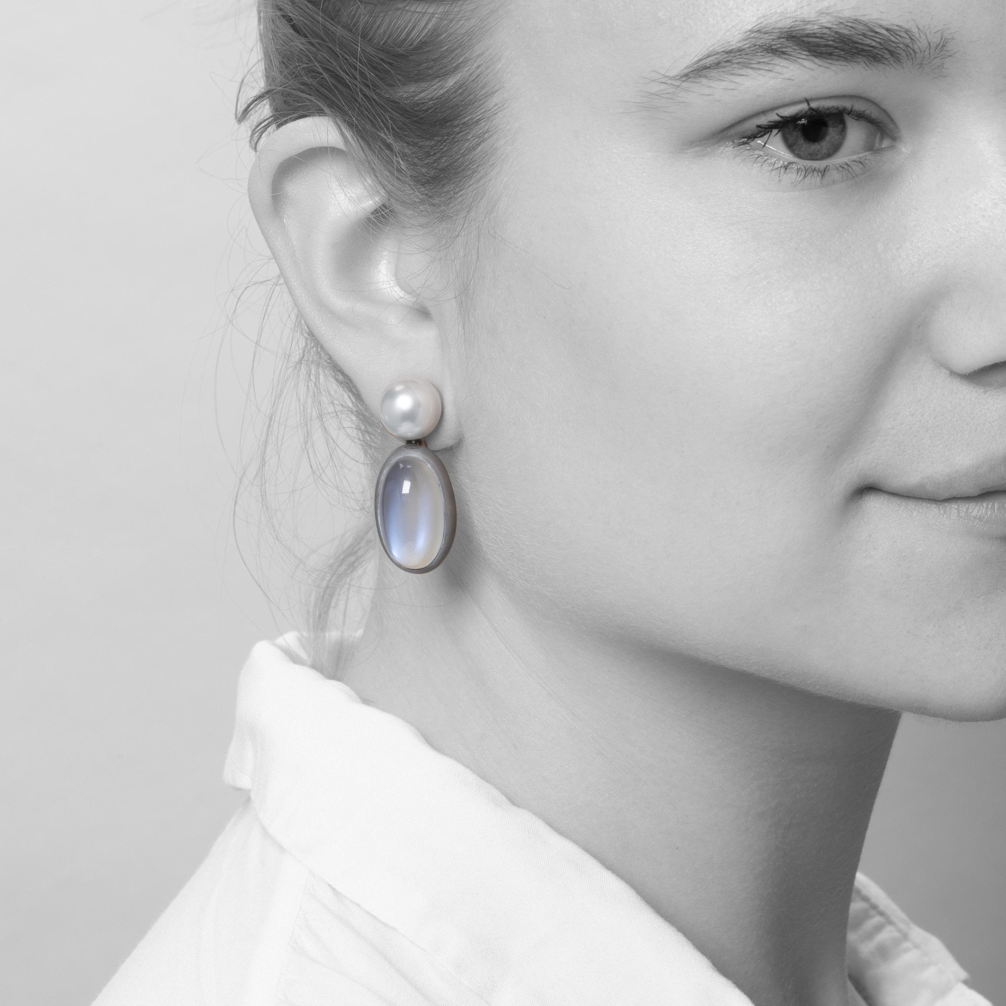 A pair of eighteen-carat white gold earrings, set with a South Sea pearl and a moonstone in aluminium. Signed Hemmerle, made in Munich. With original pouch.