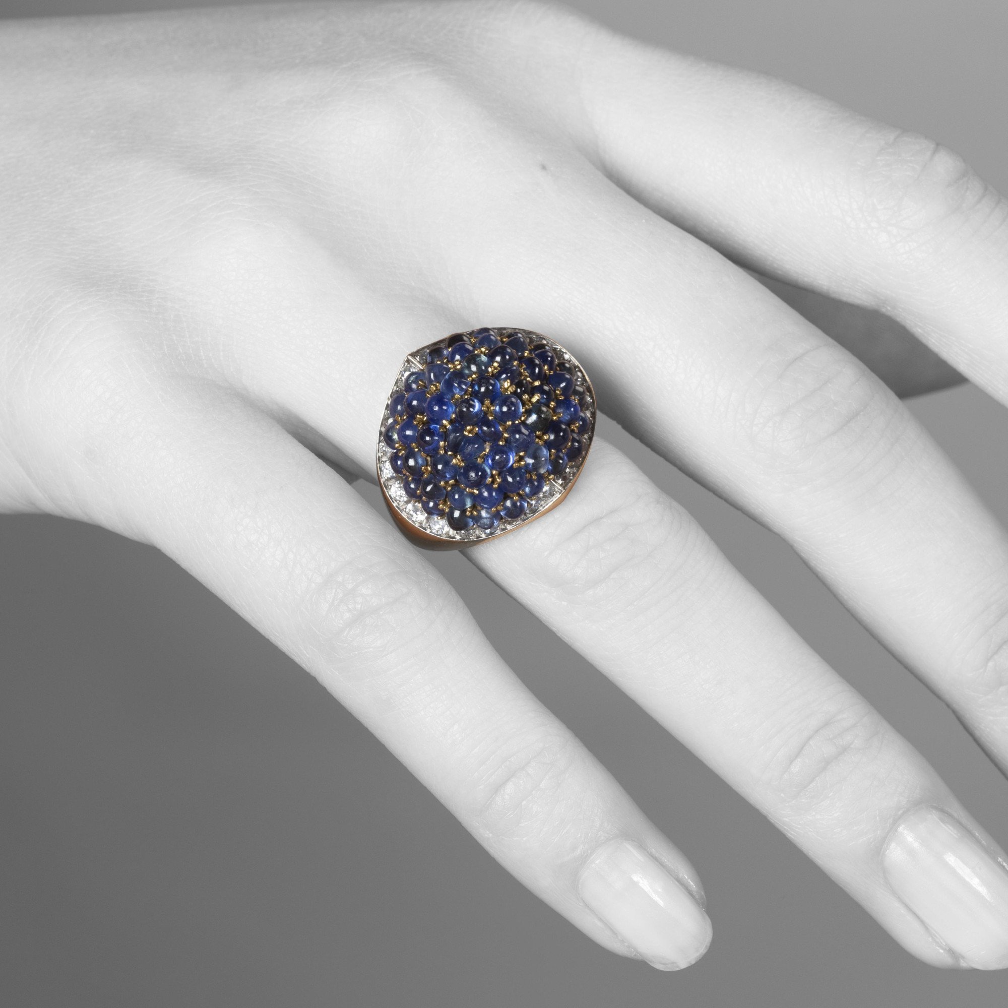 An eighteen carat yellow gold and platinum ring, pavé set with sapphires, surrounded by brilliant-cut diamonds. Signed Van Cleef & Arpels and numbered.