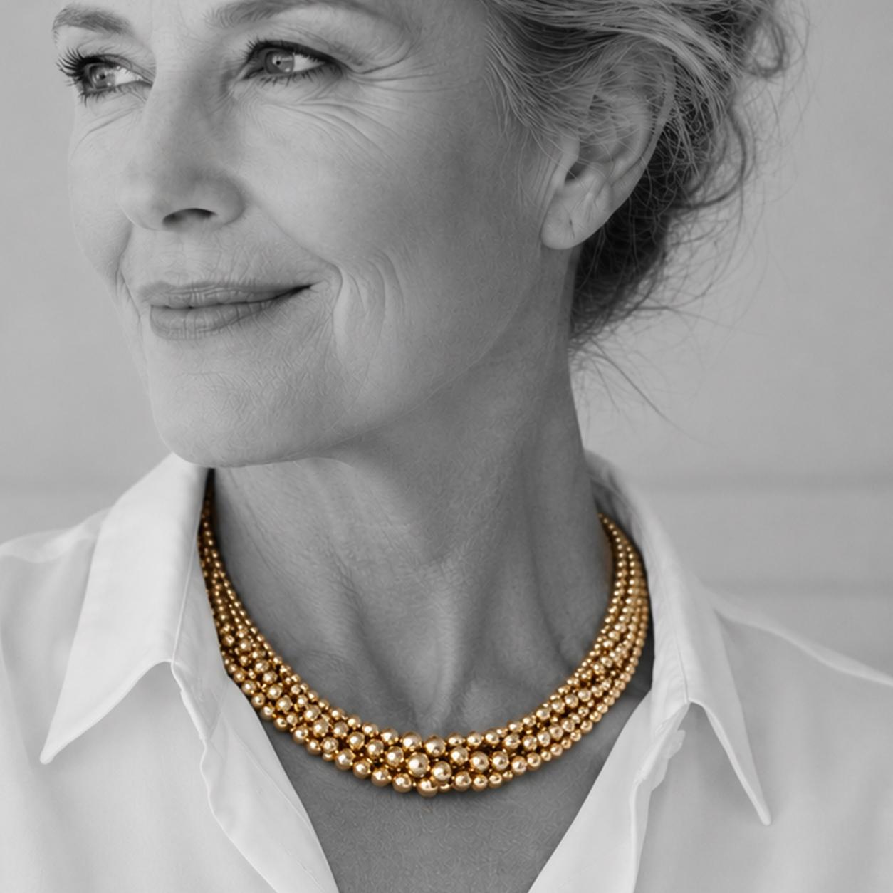 An eighteen carat yellow gold necklace composed of strands of plain round beads. Signed Cartier, made in Paris, manufactured circa 1950.
